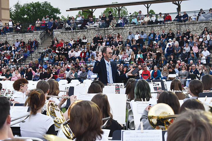 Doug Smelser directs band students during a graduation ceremony in 2022.